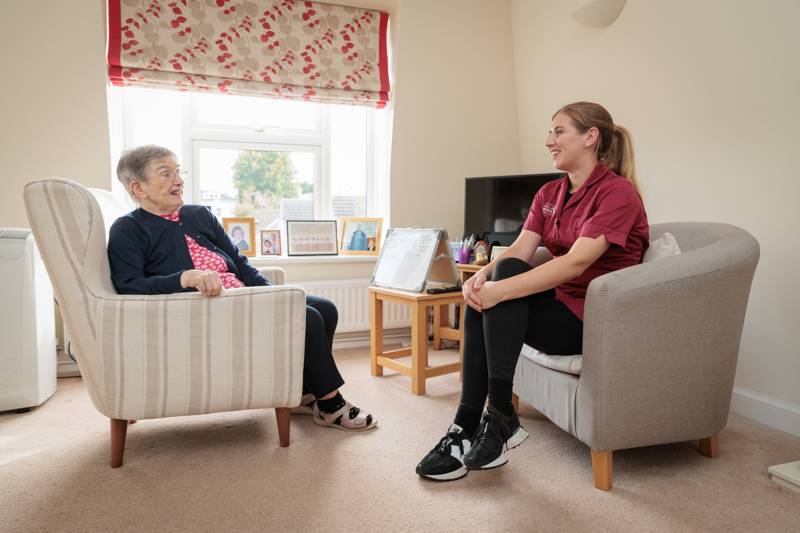 A carer and client talking in the living room